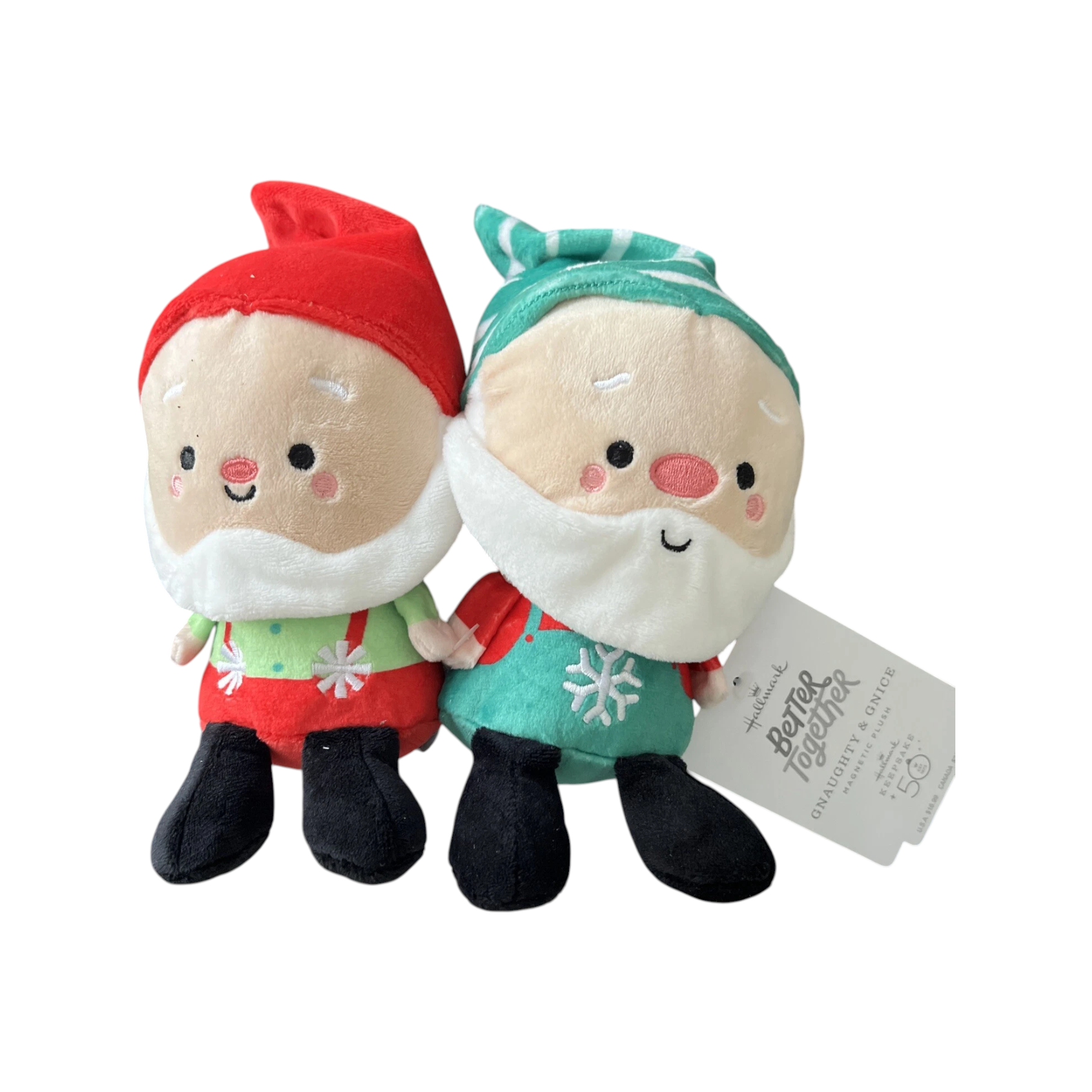 Two plush toys resembling Santa Claus and a gnome, wearing Christmas-themed outfits, with a tag on a white background.
