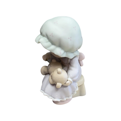 Adorable girl sews patch onto beloved teddy bear