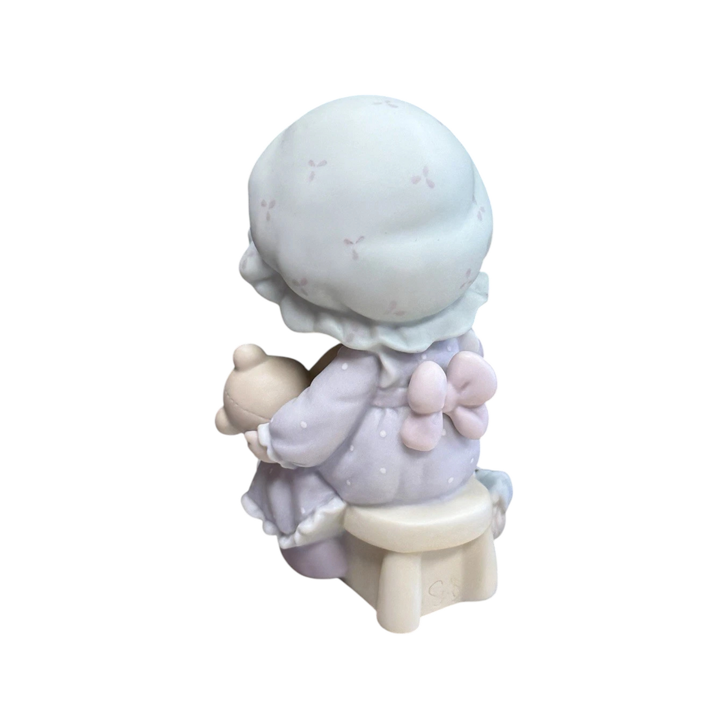 Adorable girl sews patch onto beloved teddy bear