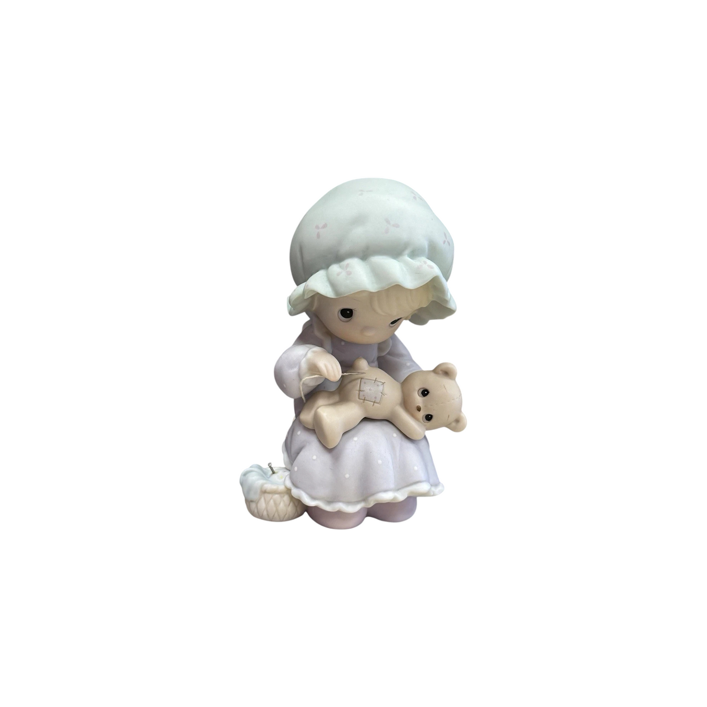 Adorable girl sews patch onto beloved teddy bear Image1