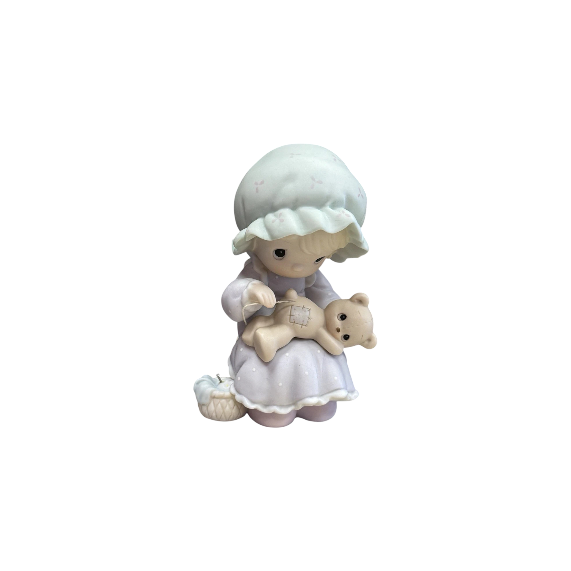 Adorable girl sews patch onto beloved teddy bear Image1
