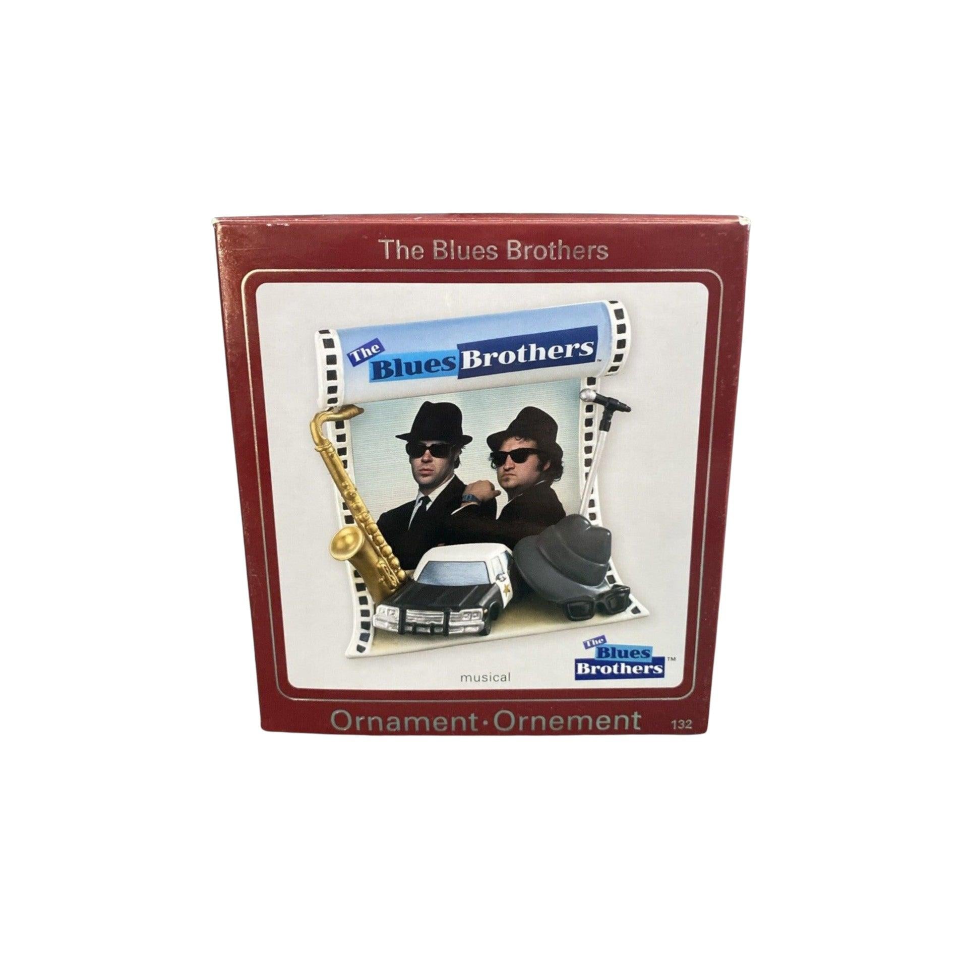 Blues Brothers ornament packaging with two men, saxophone, and car illustration.