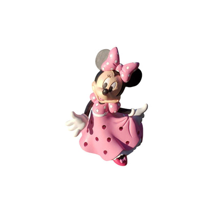 Minnie Mouse figurine in a pink dress with a bow on a white background
