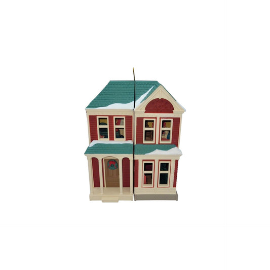 Model of a two-story house with a green roof on a white background