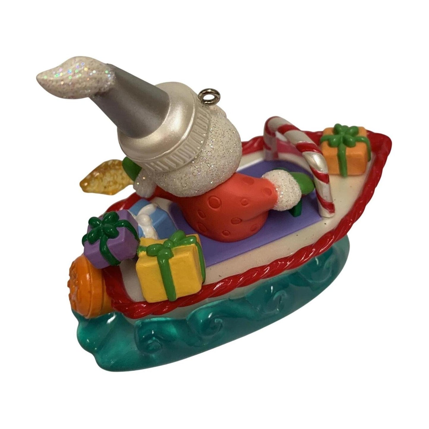 Christmas ornament of a snowman on a boat with presents and candy canes.