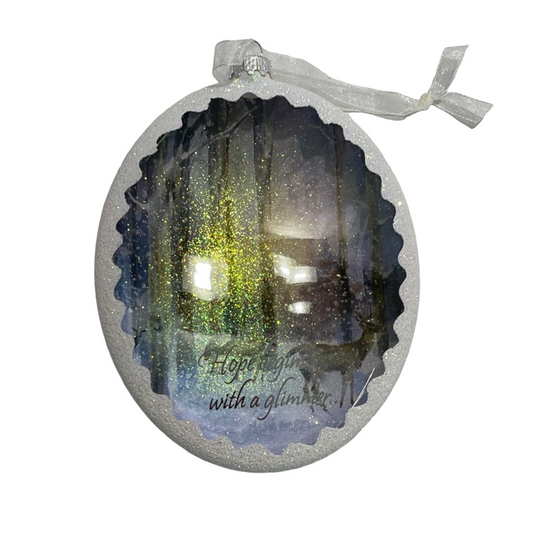 Decorative ornament with a forest scene and text on a white background