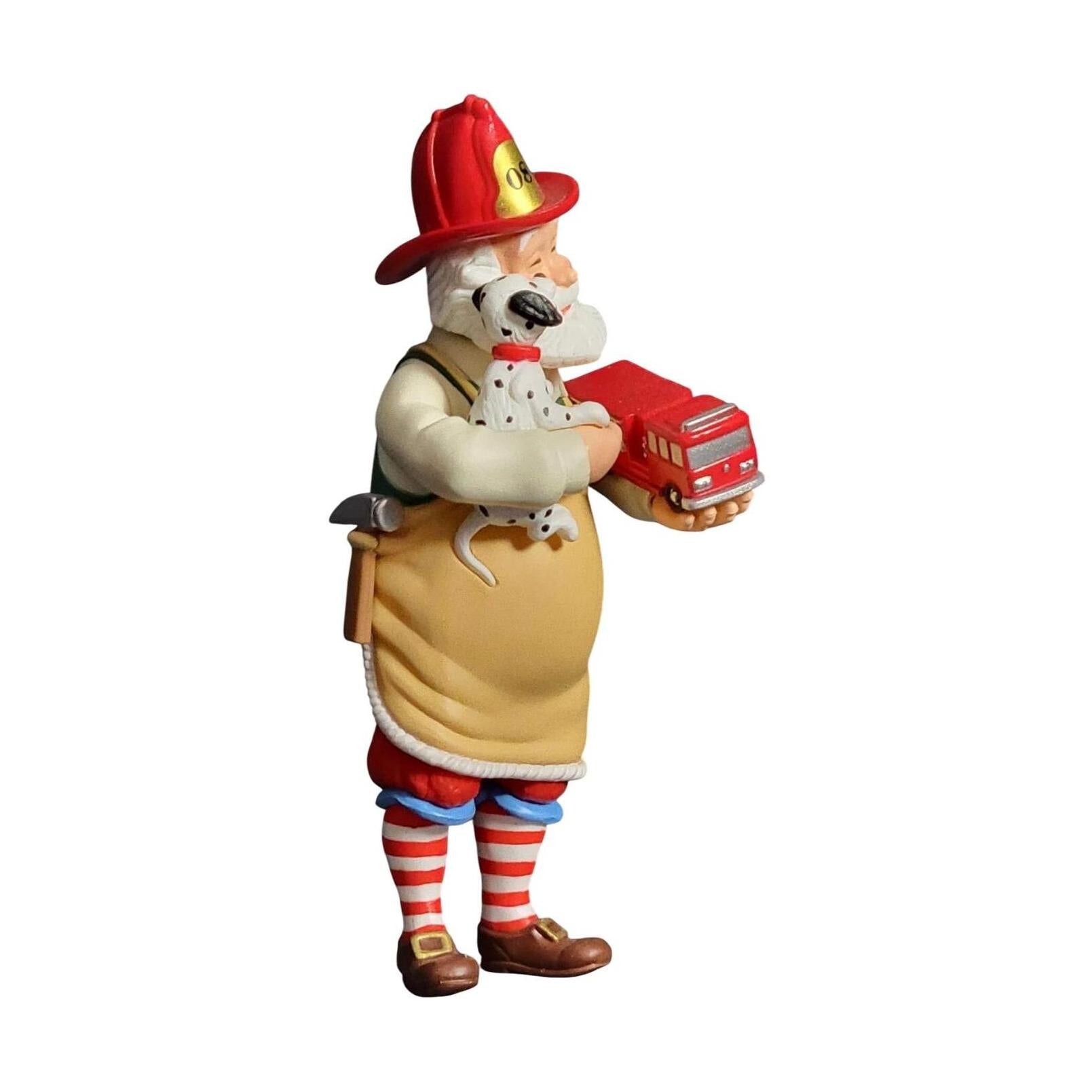 Dog figurine in firefighter costume holding a small fire truck on a white background