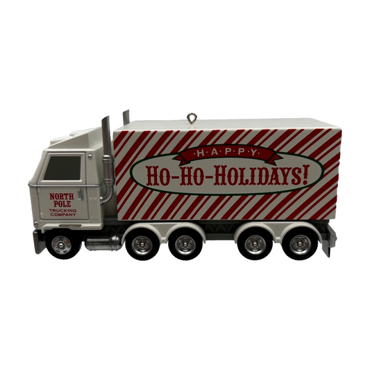 Decorative truck ornament with 'Happy Ho-Ho-Holidays!' text on a white background