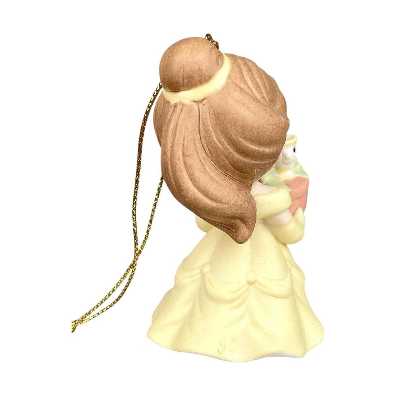 Decorative figurine of a woman with brown hair and a yellow dress on a white background