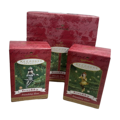 Two red boxes containing 'Friendship Elves' Christmas ornaments on a white background