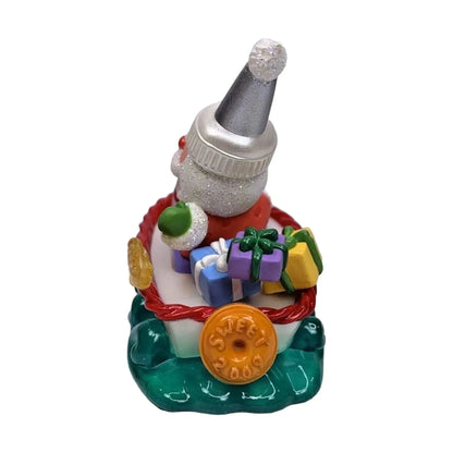 Colorful Christmas-themed figurine with a Santa hat and presents on a white background