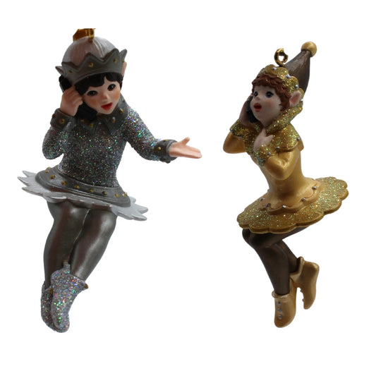 Two decorative figurines, one in silver and one in gold, on a white background.